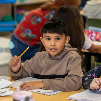Boy writing and smiling
